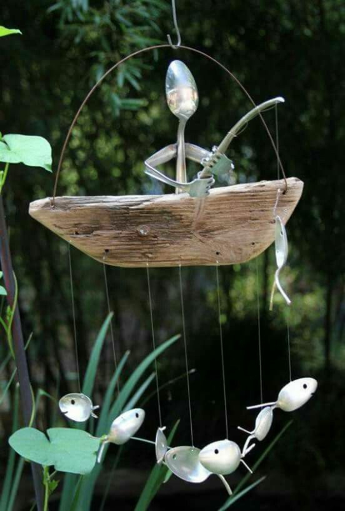 composition décorative avec des cuillères, pêcheur avec des poissons qui flottent dans l'air avec des petites cordes transparentes, decorer son jardin 
