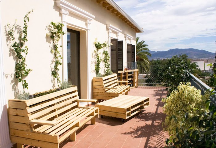 decoration terrasse avec un salon de jardin palette avec banquette palette et table basse bois de palette, sol en carrelage marron