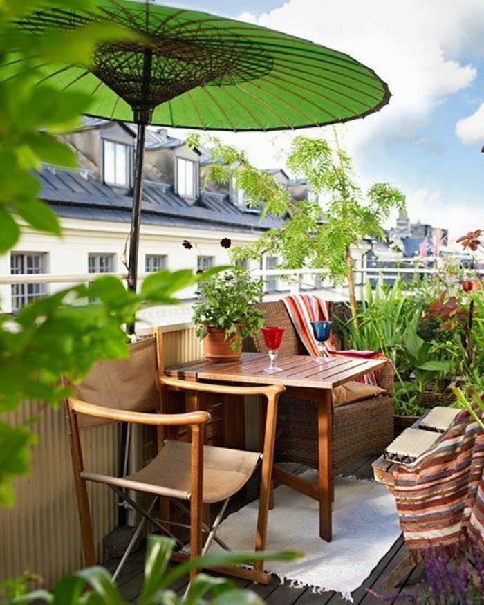 idee deco terrasse,balcon fleuri, grand parasol vert herbe en style chinois, meubles en bois clair avec des chaises en bois et tissu en lin