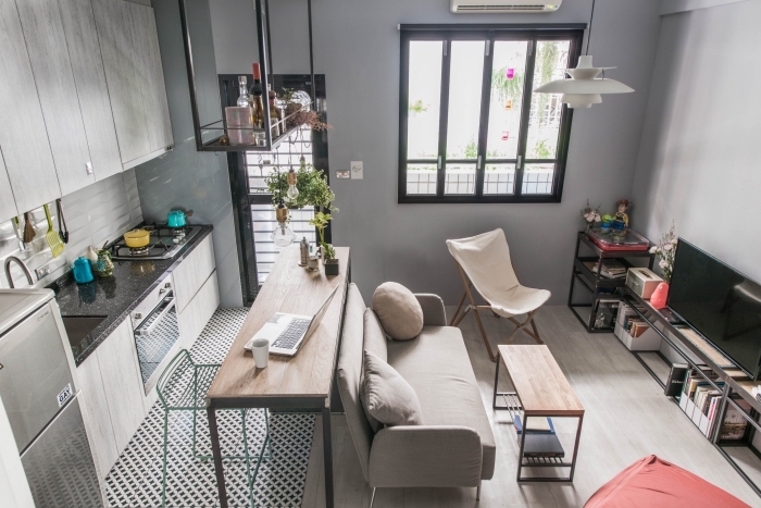 design intérieur cozy dans un studio avec petite cuisine et salon aménagé avec meubles fonctions de bois clair