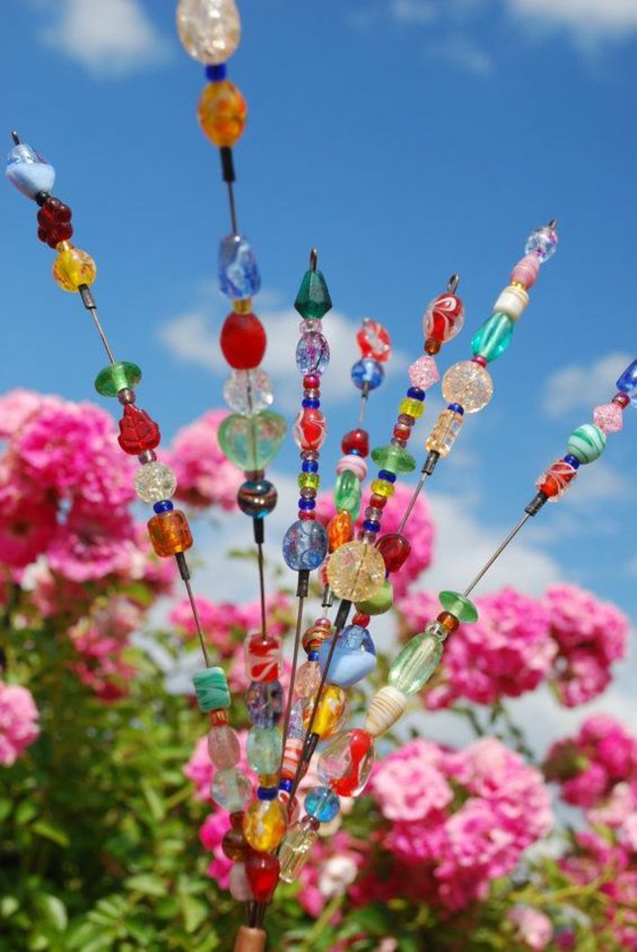 des accessoires hauts en couleurs parmi les fleurs, faites-les vous-même, décorer son jardin, pelouse rendu gaie et brillante avec des éléments scintillants 