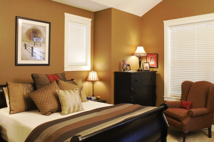 une petite chambre zen en couleur chaude, fauteuil marron, peinture encadrée originale