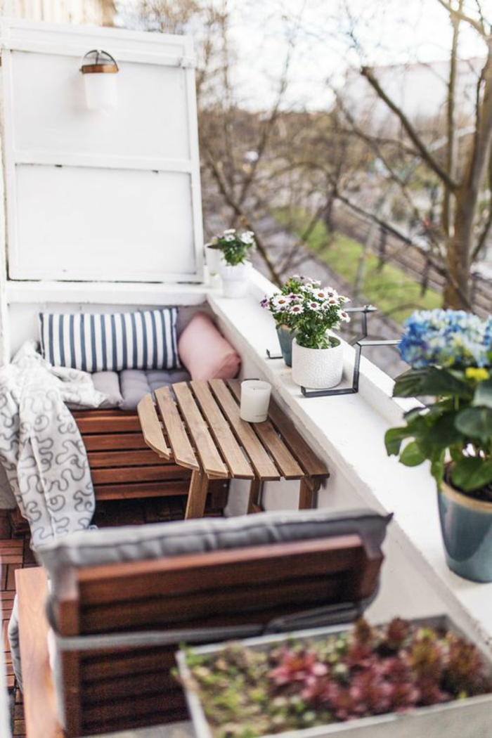 coin de relax extérieur, amenagement petite terrasse avec des meubles en palettes, table palettes pliante sur le garde-corps, pots de fleurs avec des marguerites blanches et bleues