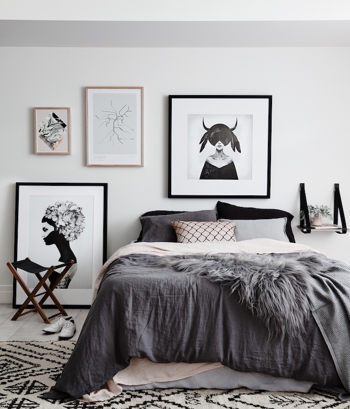 exemple de tete de lit scandinave, linge de lit gris et rose clair, tapis noir et blanc, deco de cadres noir et blanc sur un mur blanc