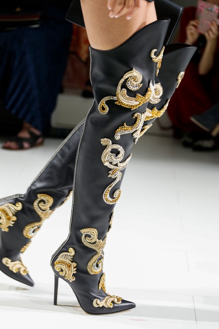 modèle de bottins à longueur au-dessus des genoux à design cuir noir avec décoration en or et argent de la collection de Versace 