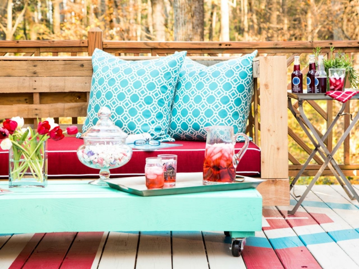 banc en palette, canapé palette, table basse en vert réséda avec des petites roues noires, grands coussins carrés en vert menthe et blanc 