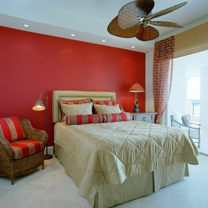 chambre à coucher déco sérène, mur rouge, fauteuil tressé, spots encastrés, grand lit blanc