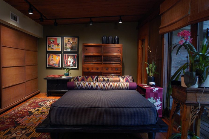 tapis bariolé, matelas gris, plateforme noire, une décoration de chambre feng shui ethnique