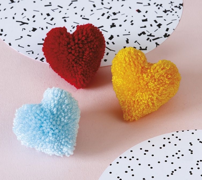 petits objets décoratifs en forme de coeur fabriqués avec pelotes de laine, comment faire des pompons en forme de coeur