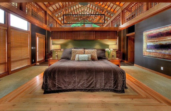 chambre à coucher chaleureuse, grand lit avec une couverture marron, plafond en bois
