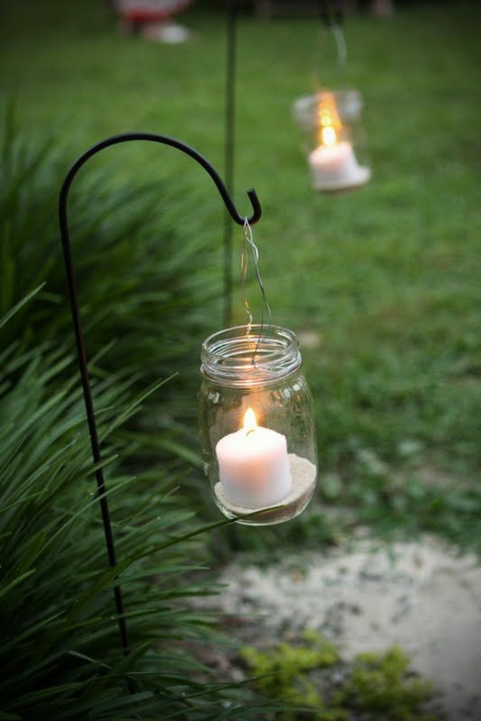 pots de confiture qui servent de bougeoirs pour illuminer la pelouse, déco jardin récup aux bougies blanches, ambiance magique