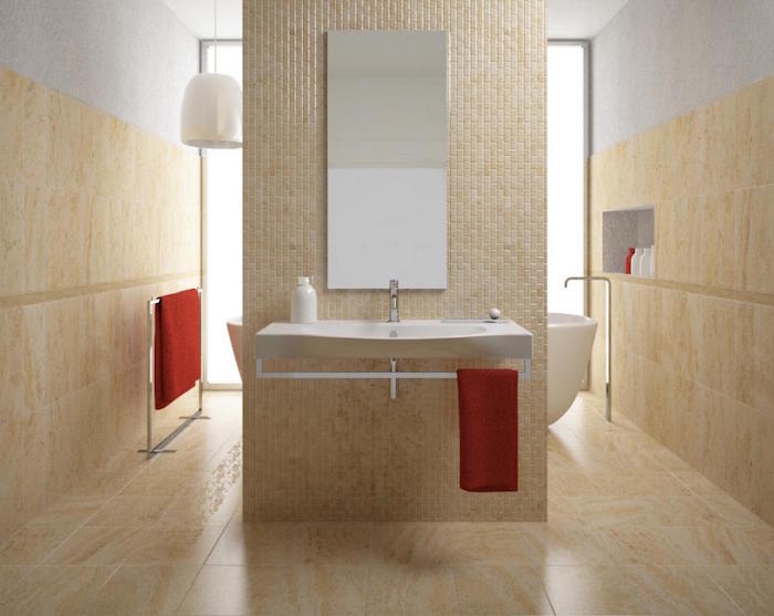 salle de bain beige marbrée carrelée sur le sol et les murs avec mur séparateur pour baignoire