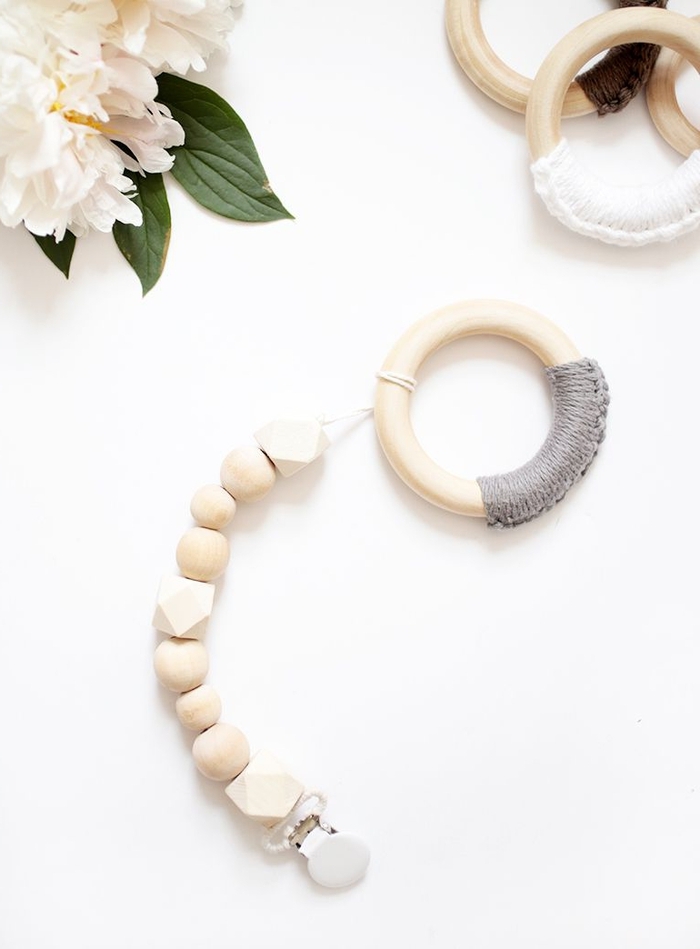 attache tétine bois réalisée avec des perles en bois rondes et hexagonales avec une pince clip blanche