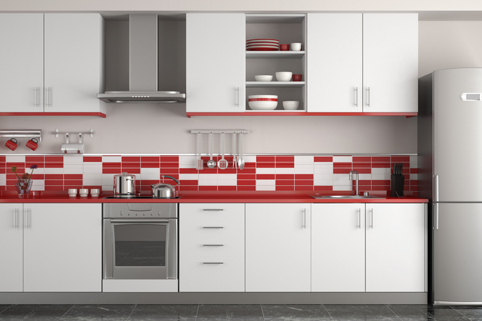 une cuisine grise et rouge aménagée en longueur avec une crédence originale en carrelage rouge et blanc 