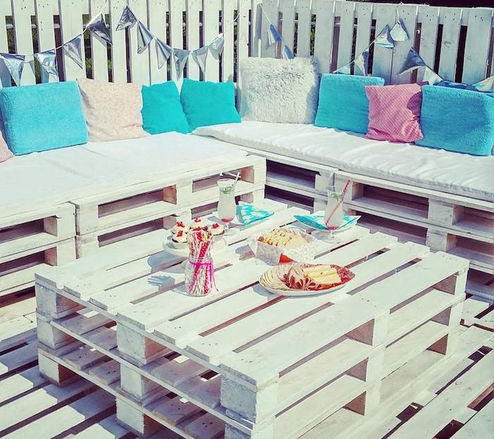 meubles de jardin en palettes de bois blanches canapé et table palette sur une terrasse en palette blanche, coussins décoratifs blanc, bleu et rose