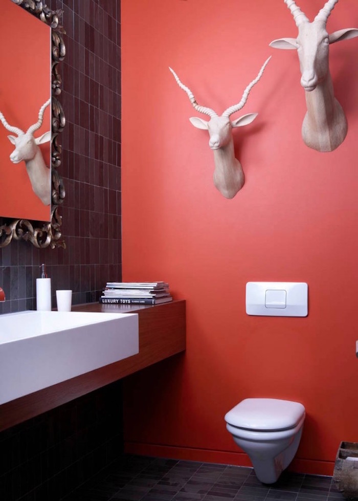 peinture toilettes idée couleur rouge clair avec tete de gazelle artificielle