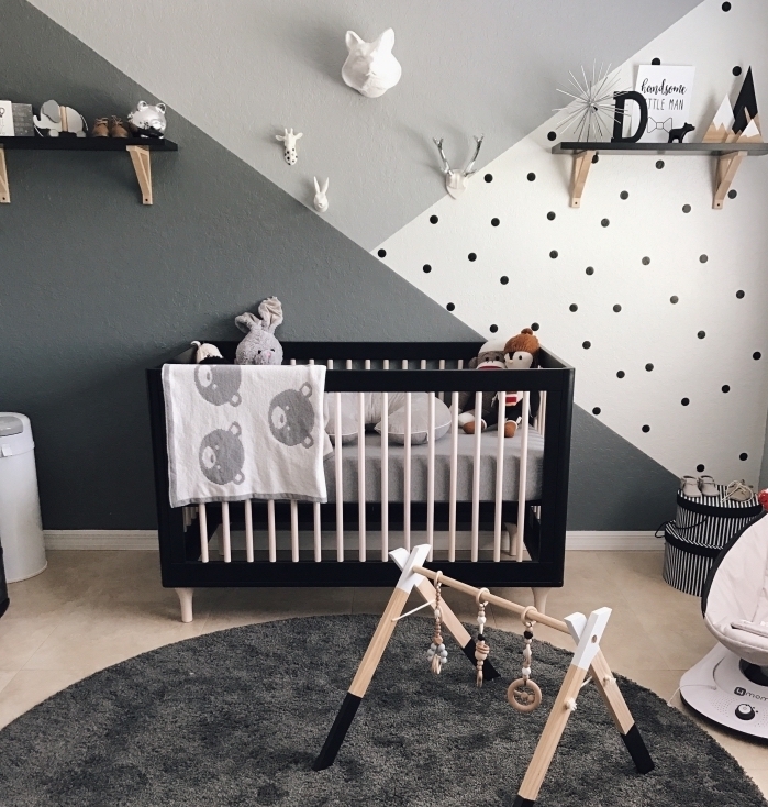 modèle de chambre bébé mixte avec décoration murale en peinture gris clair et gris foncé combiné avec pan de mur blanc à points noirs