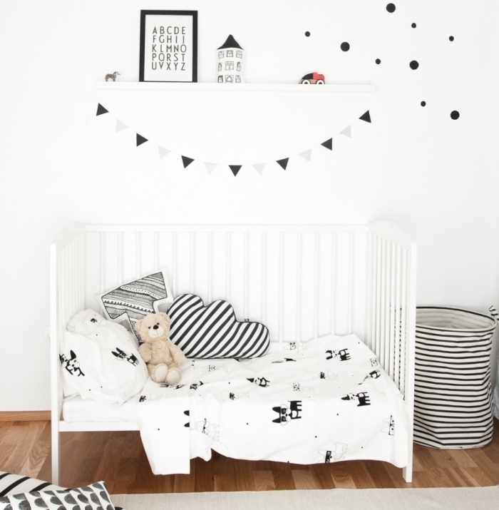 jolie chambre pour garcon aménagée de style minimaliste avec meubles et accessoires en blanc et noir sur plancher de bois foncé