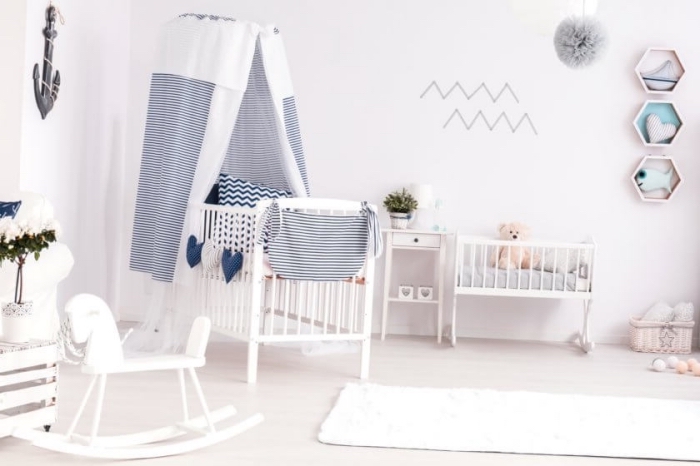 déco de chambre bébé aux murs blancs avec lit bébé blanc et bleu marine, objets décoratif en blanc et bois