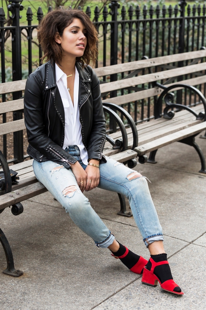 look rock chic avec paire de jeans déchirés clairs combinés avec veste en cuir noir à design studs, modèle de sandales rouges portées avec chaussettes noires