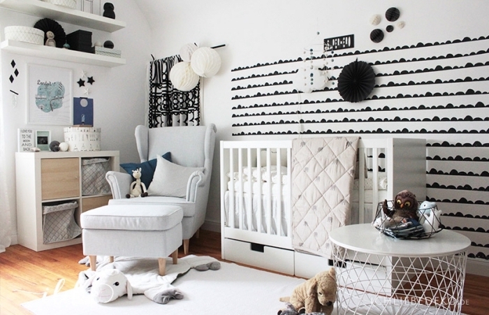 design intérieur stylé dans une chambre bébé aux murs blancs avec déco noire et étagères de bois peintes en blanc
