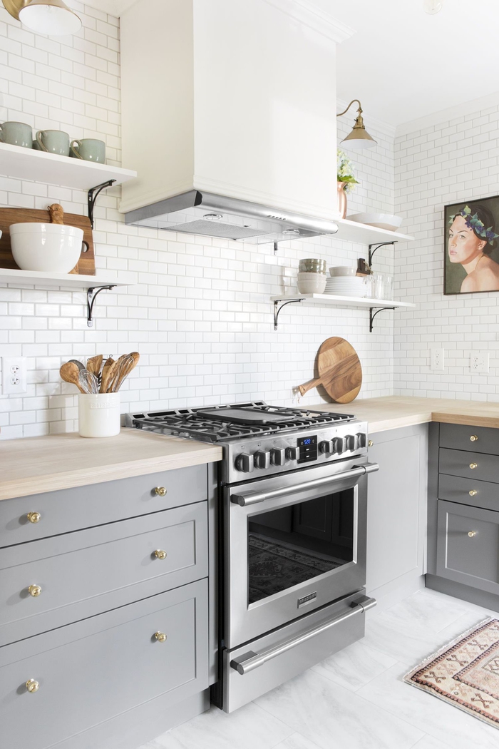 une cuisine grise et bois de style scandinave qui utilise le carrelage mural blanc et le sol effet marbre pour sublimer l espace