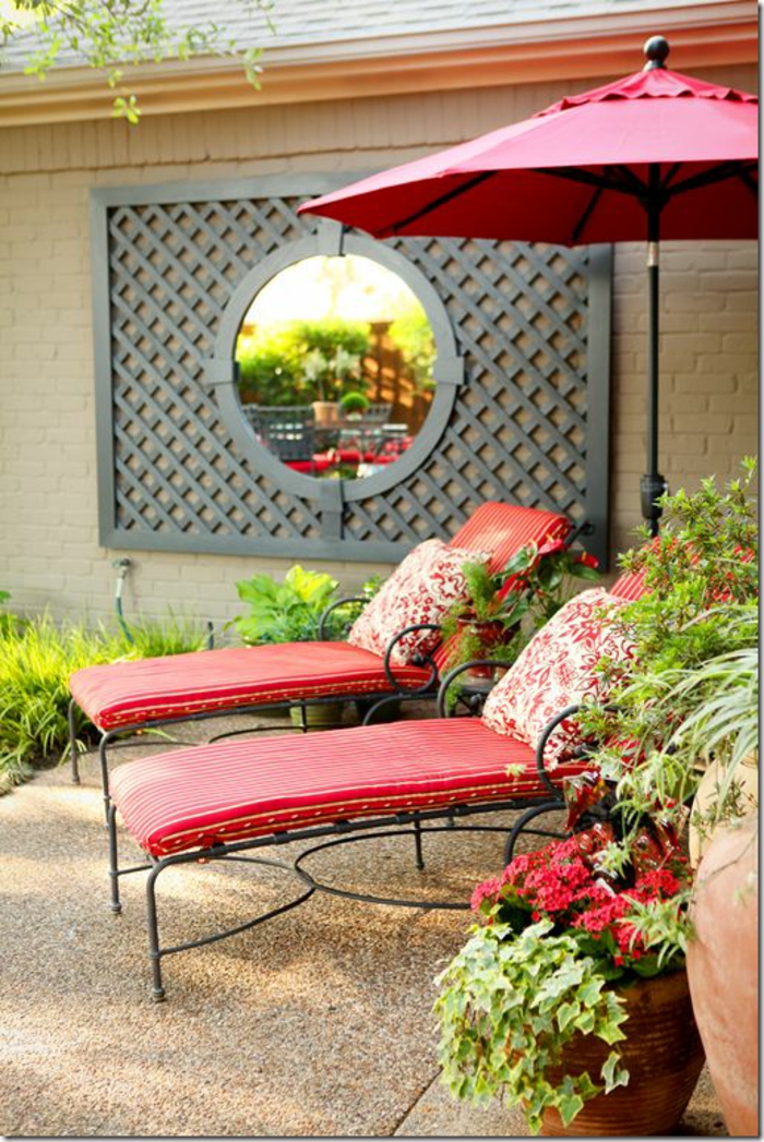 decorer son jardin avec deux chaises-longues aux coussins rouges, un miroir rond en style baroque positionné sur une pergola, parasol rouge, jardin deco, amenagement jardin
