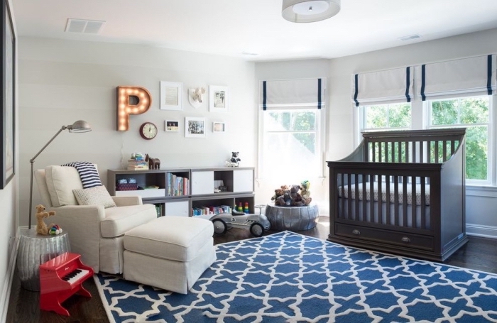 comment aménager une pièce bébé unisexe aux murs blancs et plancher foncé avec meubles fauteuil blanc et lit bébé noir