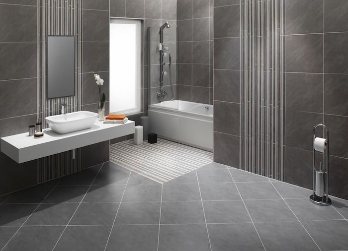 idee de salle de bain carrelée sur sol et murs en gris marbré avec baignoire et meuble lavabo suspendu