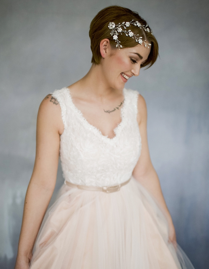 accessoire de cheveux bijou imitation branche fleurie volume sur le dessus et petite mèche de coté, robe à top blanc et jupe en tulle couleur champagne