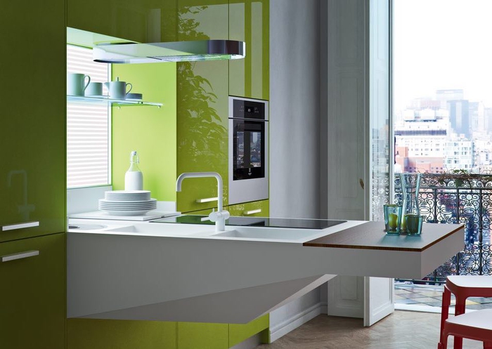 aménagement fonctionnelle et moderne d'une petite cuisine gris clair et vert laqué avec un plan de travail suspendu à évier et planche à découper intégrés