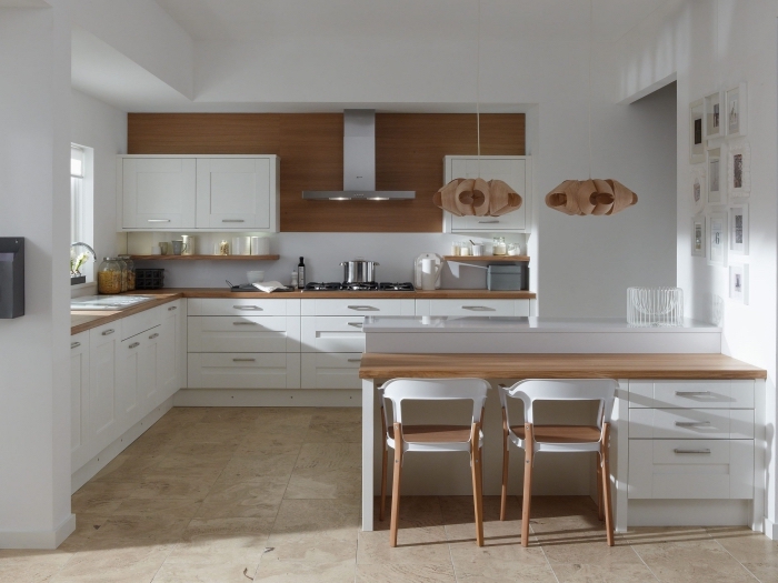 exemple de cuisine moderne aux murs blancs avec pan de mur en bois foncé, meuble plan de travail en bois stratifié
