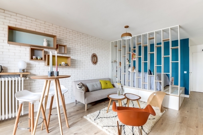 idée déco studio moderne avec revêtement mural en briques blanches et plancher de bois clair, modèle de meuble séparation pièce