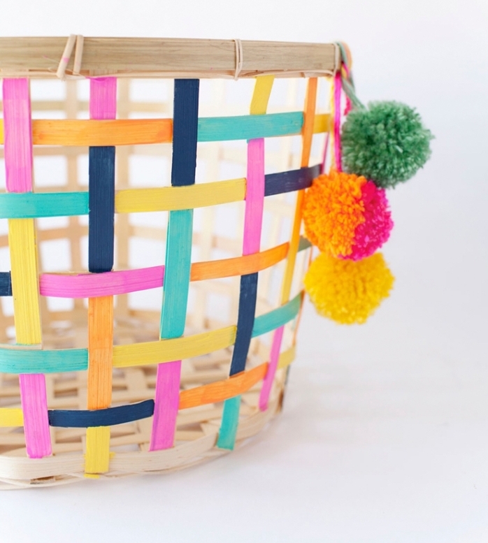 idee deco maison avec un panier peint en couleurs différentes et décoré avec quelques pompons de laine colorés