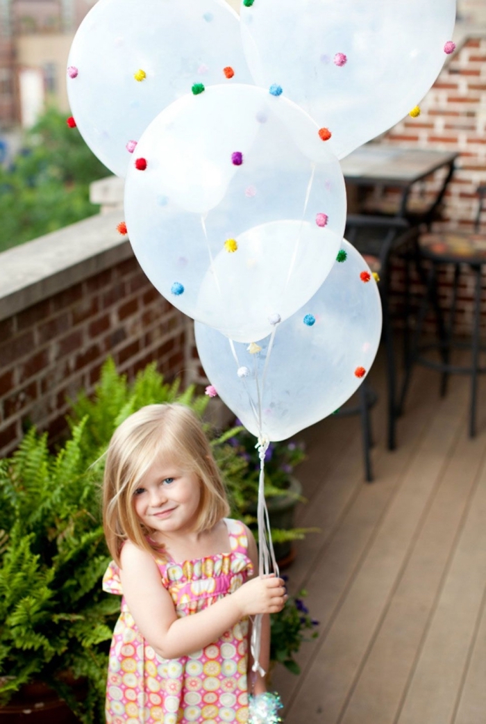idée pour la décoration festive, comment organiser un anniversaire d'enfant, déco avec ballons transparents décorés de pompons