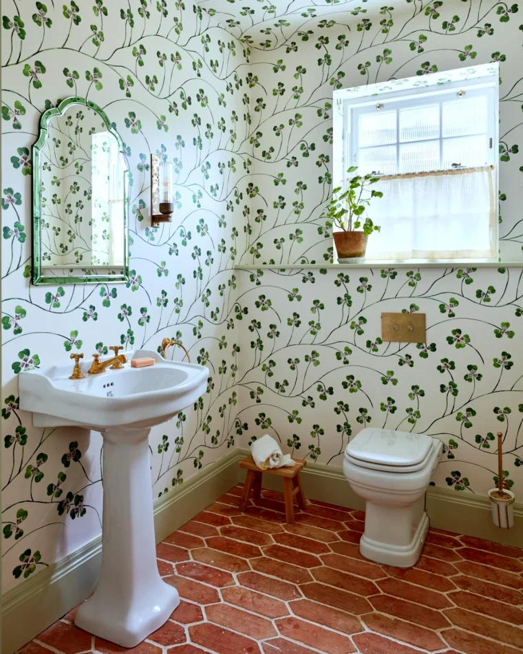 petite salle de bain avec toilettes papier peint avec des feuilles vertes