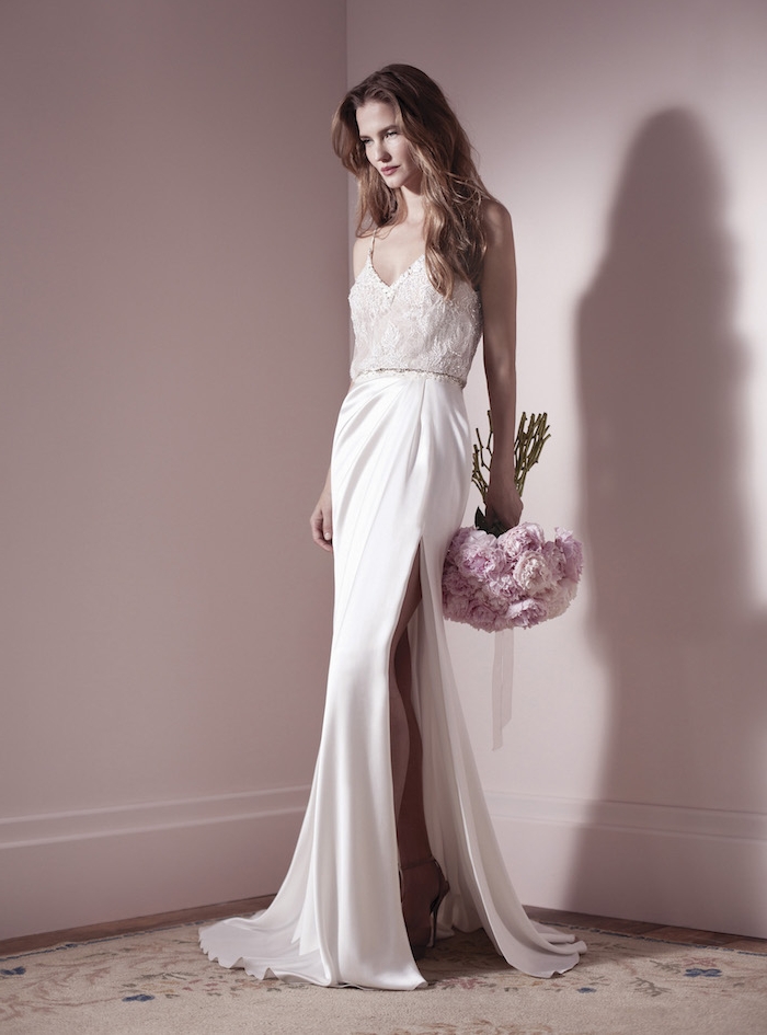 robe de mariée originale avec une jupe blanche moulante et un corsage en dentelle, bouquet de mariée rose