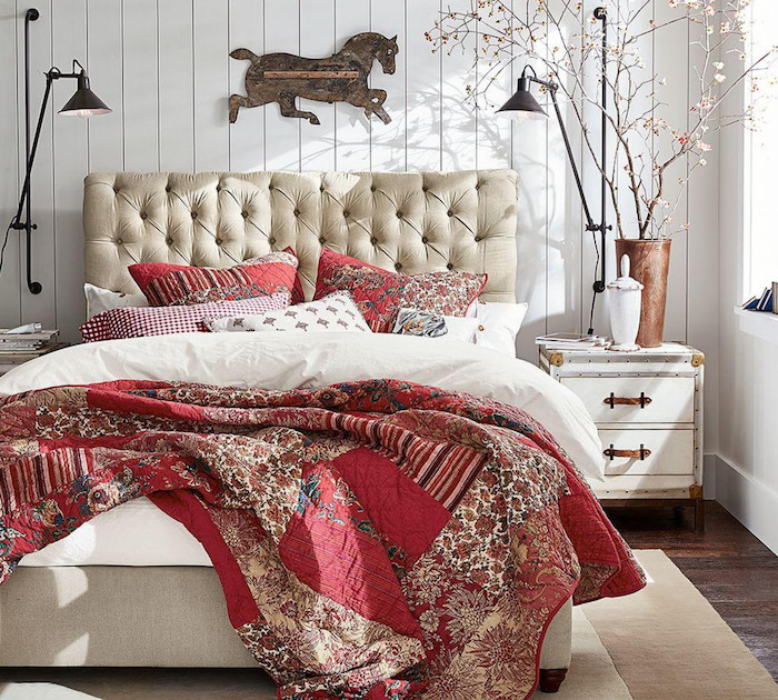 cheval en bois pour décorer une tete de lit capitonnée, linge de lit rouge et blanc, table de nuit vintage, murs en lambris blanc