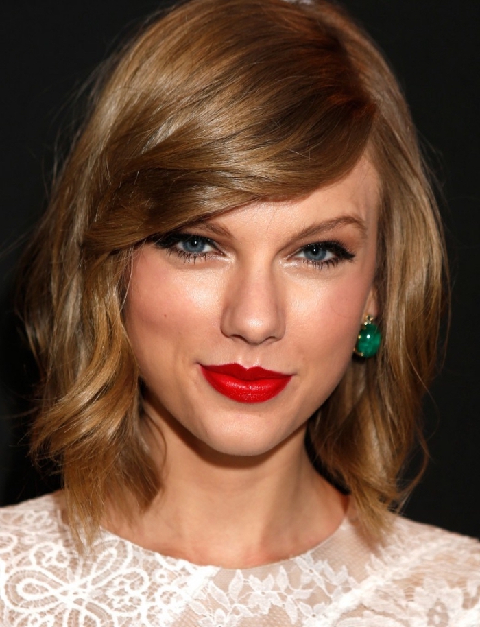 coiffure de Taylor Swift aux cheveux mi-longs avec frange de côté, couleur de cheveux châtain cuivré en carré dégradé