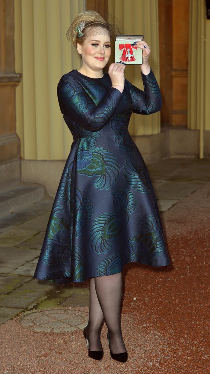 Adele en robe bleue évasée, style élégant, coiffure élégante chignon, tenue femme 