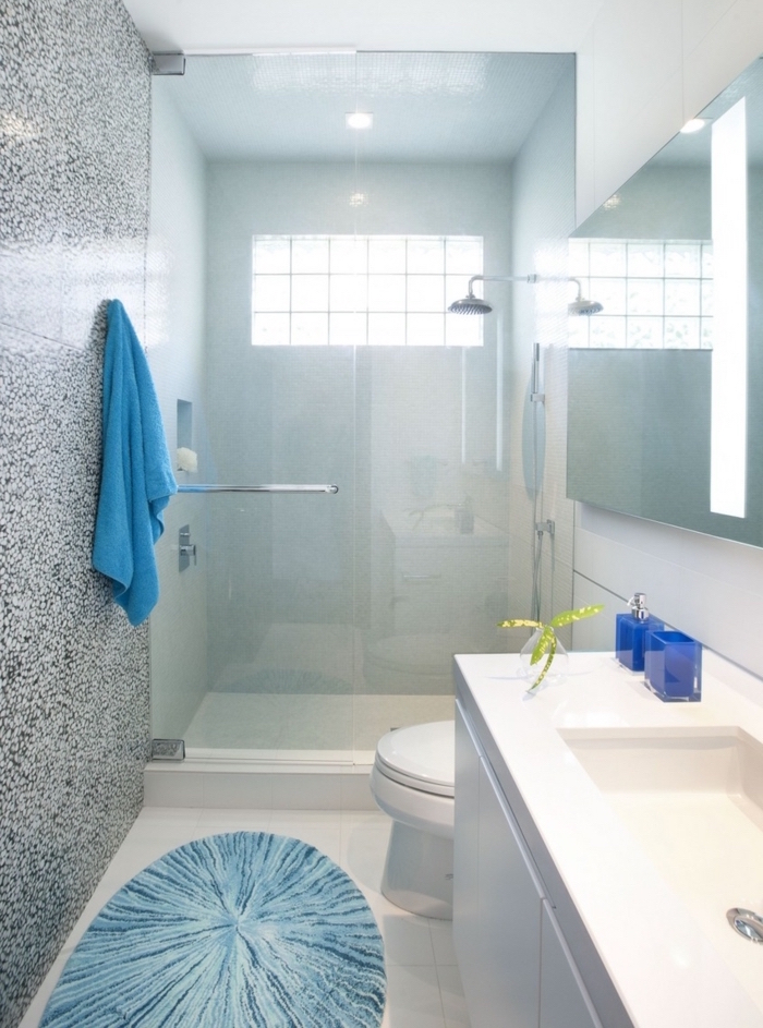 salle de bains en longueur blanche et bleue rénovée avec grande douche vitrée