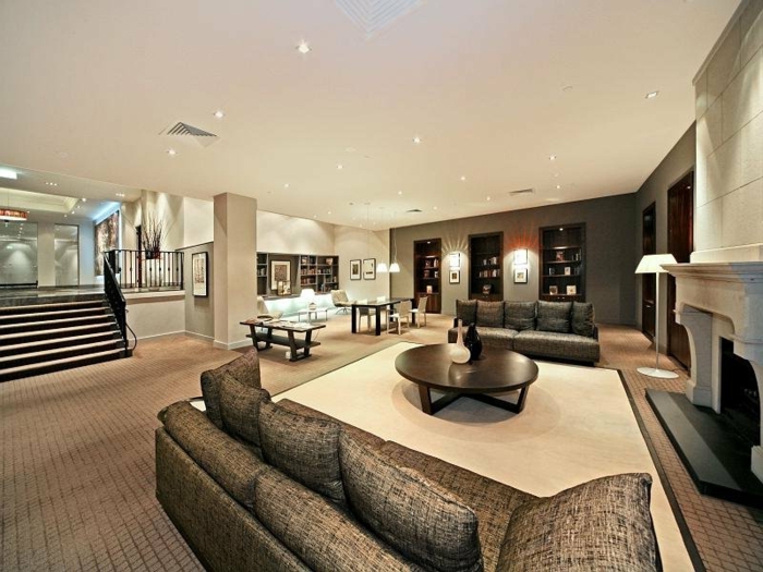 idee deco salon contemporain, sofa gris en tissu, table ronde basse, tapis beige, grande maison contemporaine