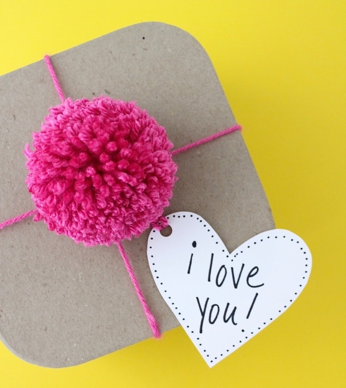 comment emballer un cadeau surprise avec fil et boule de laine de couleur rose fuschia, message mot doux je t'aime