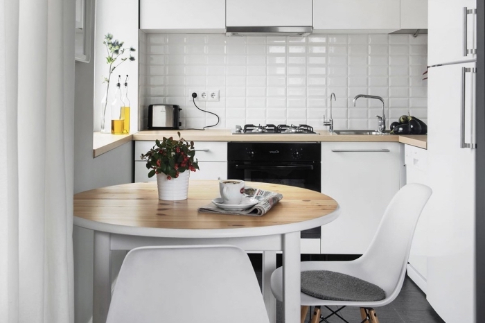 idée déco accueillante dans une petite cuisine aménagée en L avec meubles blancs à plan de travail bois clair