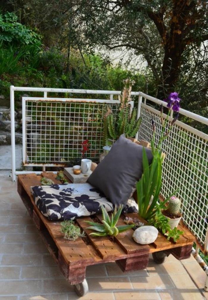 porte-plante type plateforme mobile avec des roues et des plantes exotiques, coin de terrasse vert, coussins pour s'asseoir pour une personne 