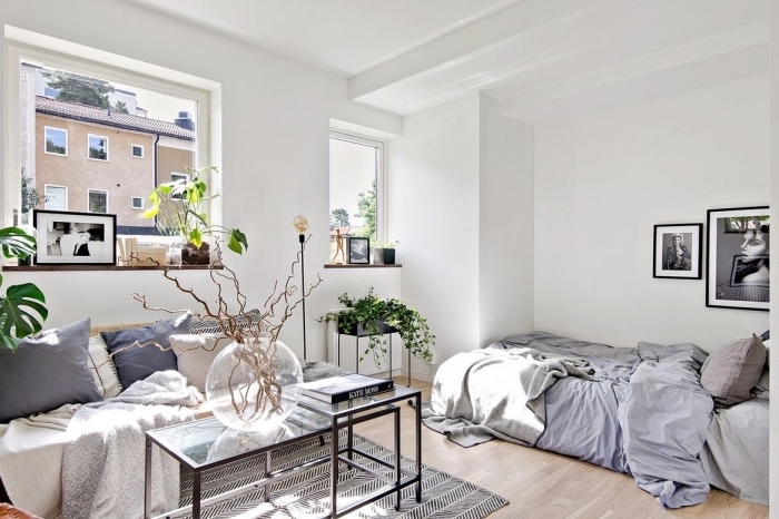 décoration appartement étudiant aux murs blancs avec accessoires cozy en forme de coussins et plaids gris et beige