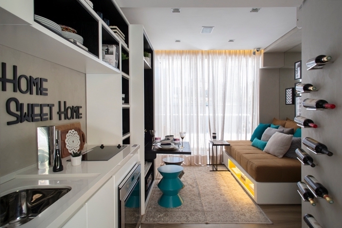 aménager un petit appartement avec cuisine en blanc noir et salon avec canapé escamotable à rangements