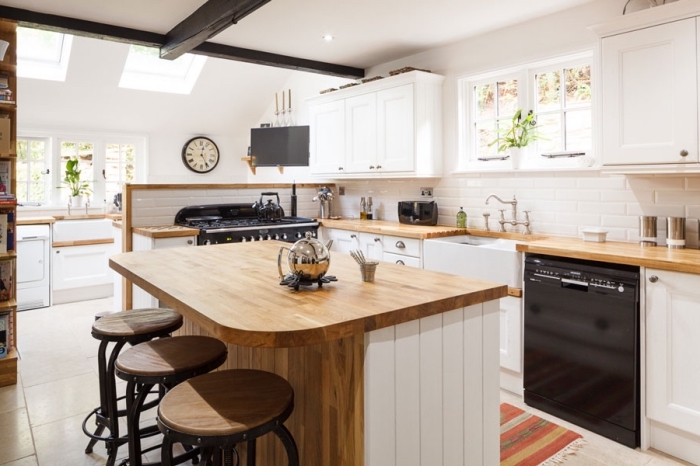 comment combiner les styles dans une déco de cuisine moderne aux murs blancs avec meubles de bois massif et accents en noir mate