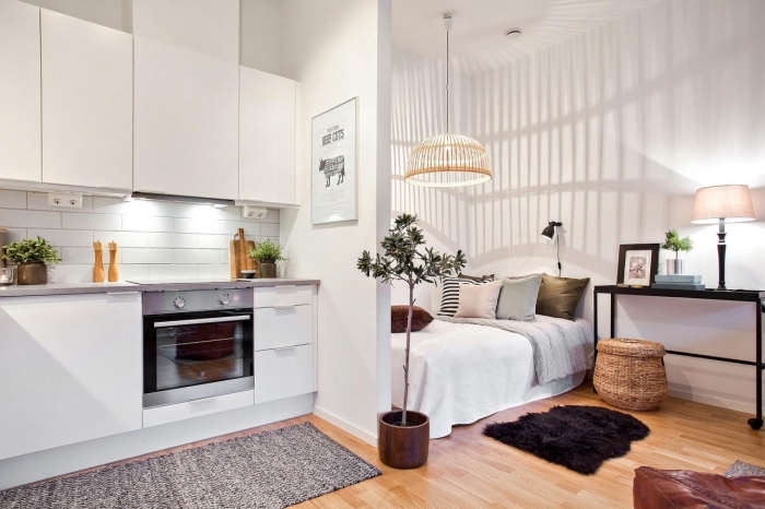 exemple de deco petit appartement avec cuisine blanche en meubles sans poignées et coin de nuit à grand lit