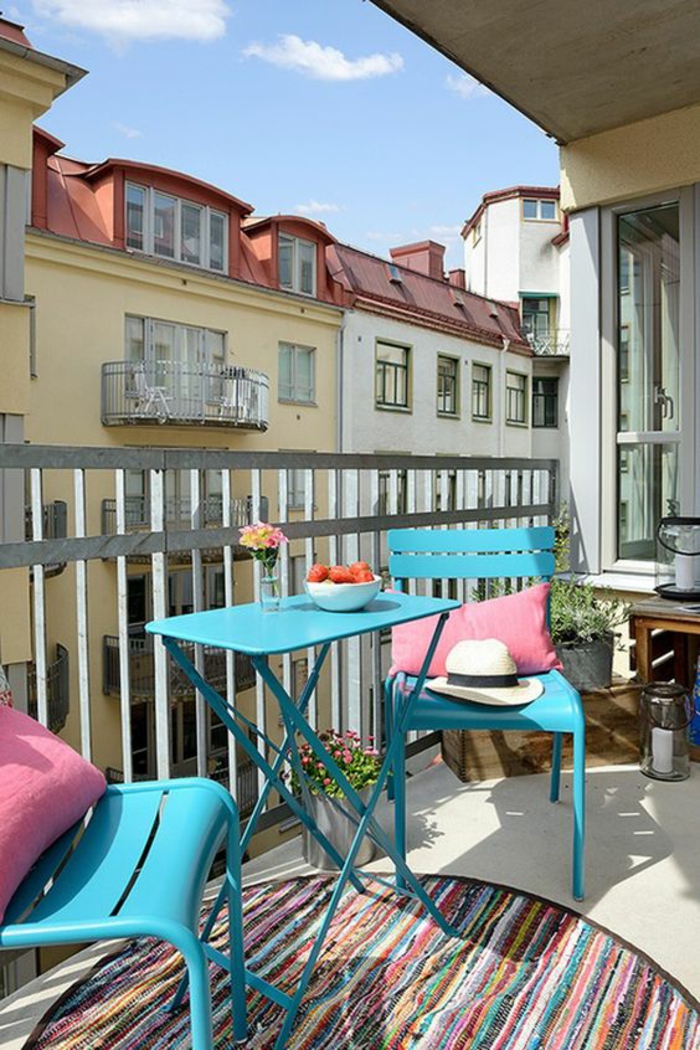 deux chaises et une table pliables en métal bleu pastel, tapis rond en style ethnique, garde-corps en métal gris, idee deco terrasse, decoration terrasse exterieur